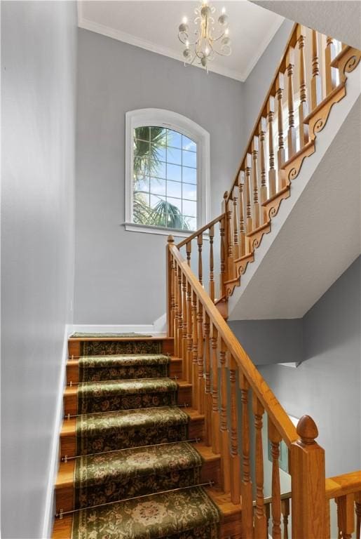 staircase featuring crown molding, hardwood / wood-style floors, and an inviting chandelier