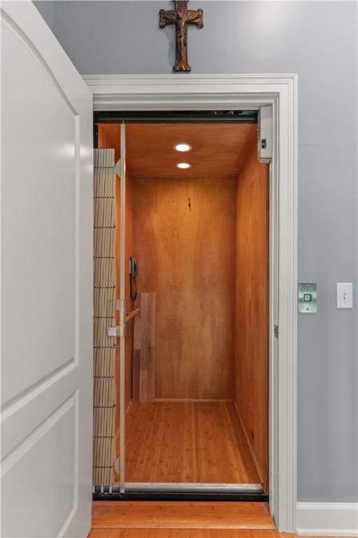 details with elevator and wood-type flooring