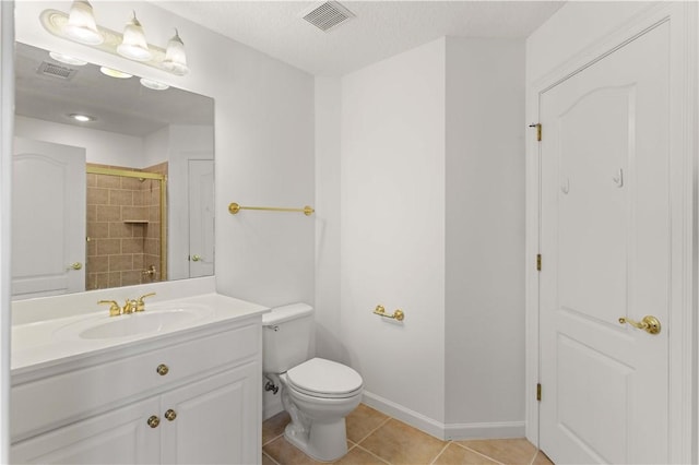 bathroom with vanity, a shower with door, tile patterned flooring, toilet, and a textured ceiling