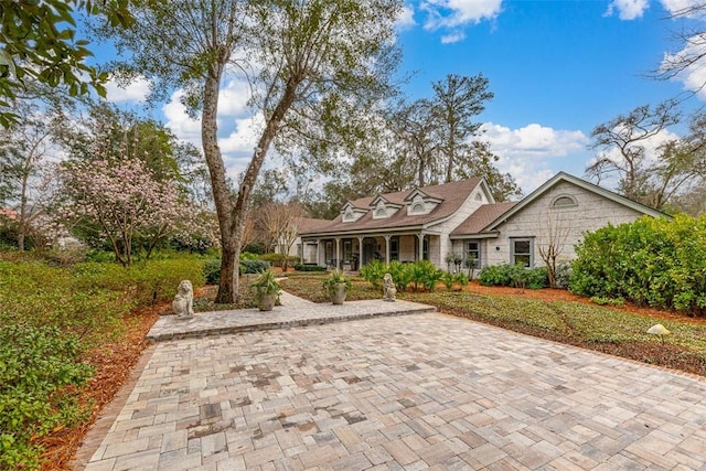 cape cod-style house featuring covered porch