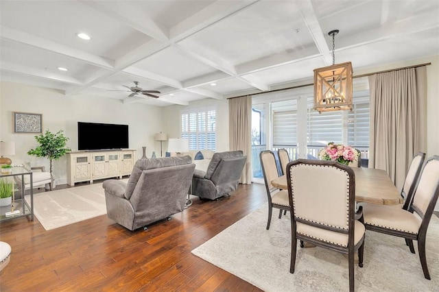 dining space featuring dark hardwood / wood-style flooring, beamed ceiling, ceiling fan with notable chandelier, and coffered ceiling