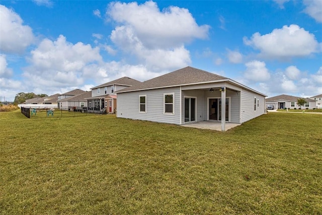 rear view of property featuring a patio and a lawn