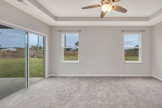 unfurnished room with carpet floors, ceiling fan, and a tray ceiling