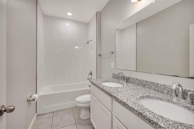 full bathroom featuring tile patterned flooring, tiled shower / bath, vanity, and toilet