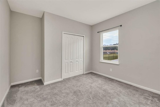 unfurnished bedroom featuring light carpet and a closet