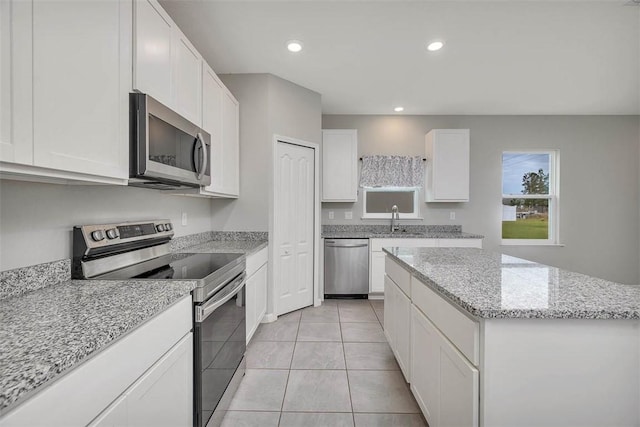 kitchen with white cabinetry, appliances with stainless steel finishes, a center island, and sink