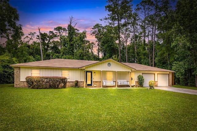 1201 Fairway Rd, Brunswick, GA 31525 - ranch-style home featuring a porch, concrete driveway, a lawn, and an attached garage