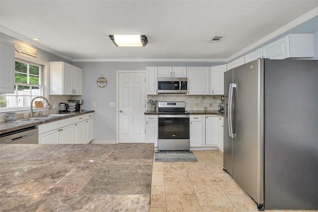 1201 Fairway Rd, Brunswick, GA 31525 - kitchen featuring stainless steel appliances, a sink, backsplash, white cabinets, and crown molding