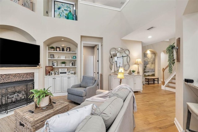 living room with light wood-type flooring and built in shelves