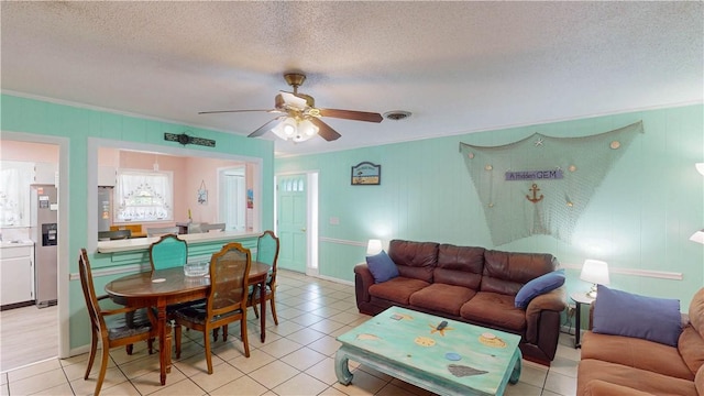 living area with ceiling fan, a textured ceiling, light tile patterned floors, and crown molding