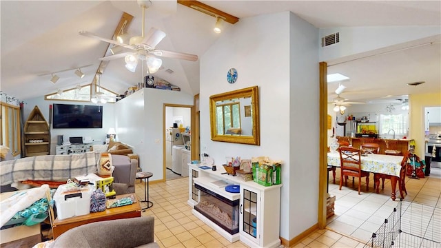 living area with a ceiling fan, washer and dryer, light tile patterned floors, and rail lighting
