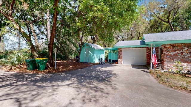 garage with driveway and a storage unit
