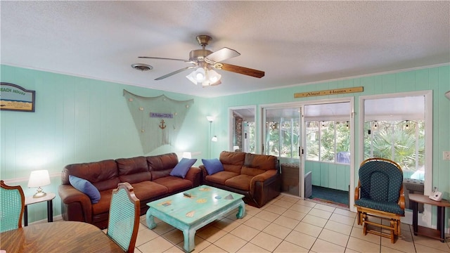 living area featuring ceiling fan, light tile patterned floors, and a textured ceiling