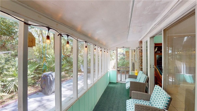 sunroom / solarium featuring healthy amount of natural light and lofted ceiling