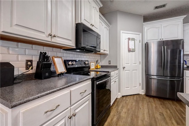 kitchen with backsplash, black appliances, wood finished floors, and white cabinetry