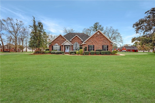 view of front facade with brick siding and a front yard