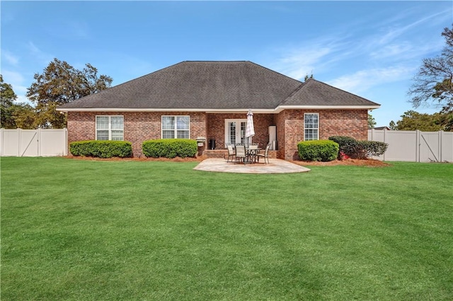 rear view of house featuring a fenced backyard, a lawn, and a patio