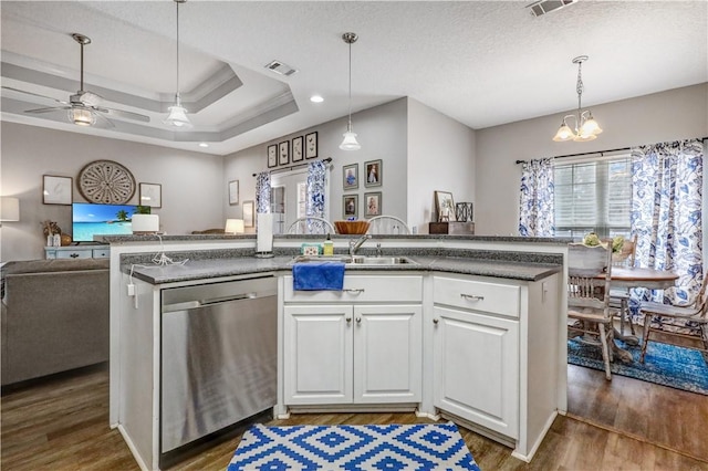 kitchen with visible vents, stainless steel dishwasher, wood finished floors, open floor plan, and a raised ceiling