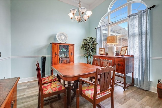 dining area featuring a notable chandelier, wood finished floors, and baseboards