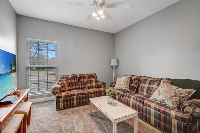 carpeted living room with baseboards and a ceiling fan