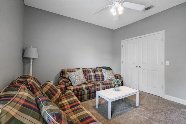 living area with visible vents, baseboards, carpet flooring, and a ceiling fan