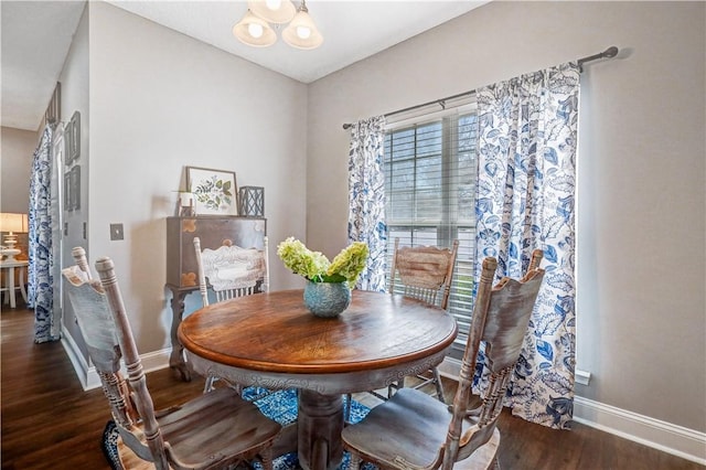 dining area featuring baseboards, a notable chandelier, and wood finished floors