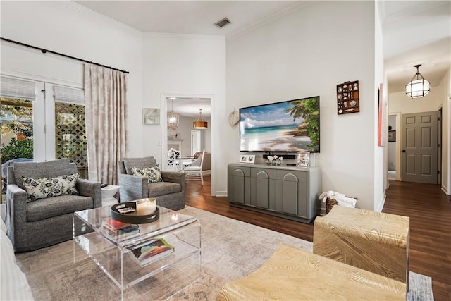 living room featuring ornamental molding, a towering ceiling, and dark hardwood / wood-style flooring