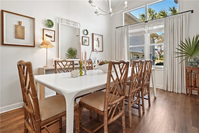 dining room with a notable chandelier and dark wood-type flooring