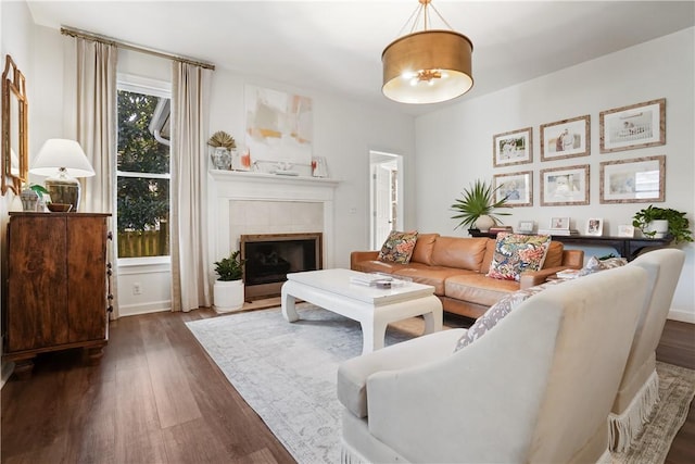 living room with dark wood-type flooring and a tiled fireplace