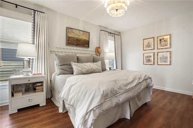 bedroom with dark hardwood / wood-style flooring and a chandelier