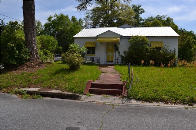 300 Blackwell St, Waycross, GA 31501 - view of front facade featuring stucco siding, metal roof, and a front lawn