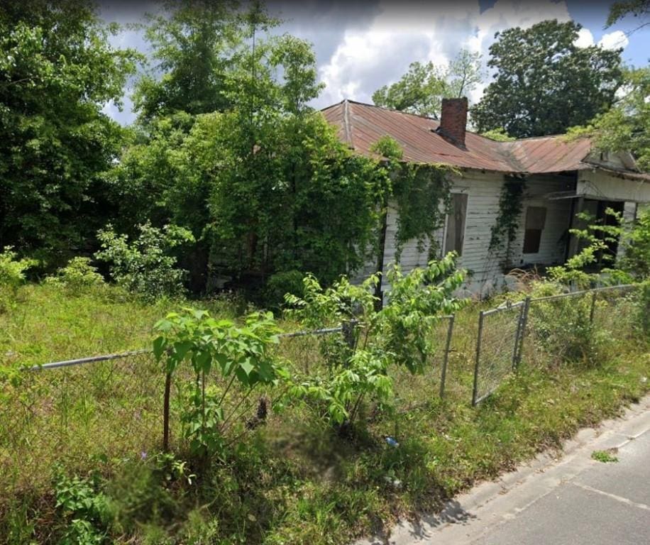 914 Pittman St, Waycross, GA 31501 - view of home's exterior with a metal roof and a chimney