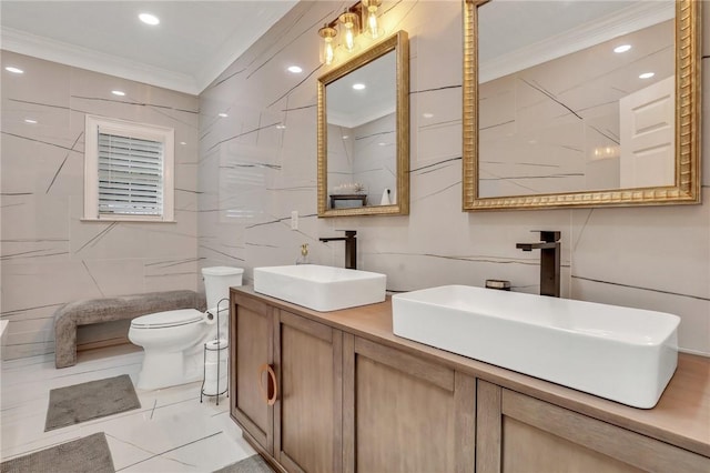 bathroom featuring toilet, vanity, tile walls, and ornamental molding