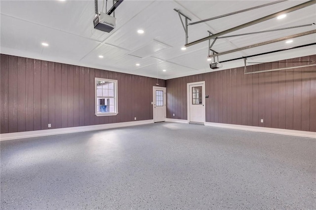 garage with wood walls and a garage door opener