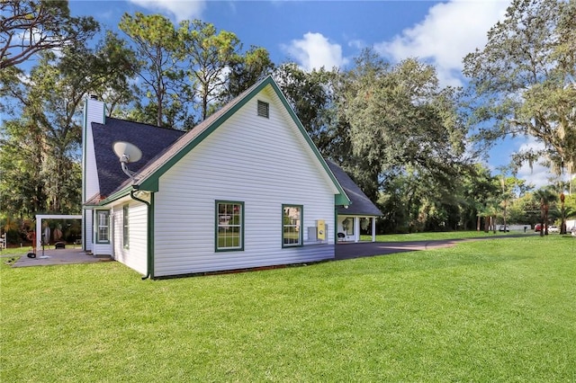 back of property featuring a lawn and a patio