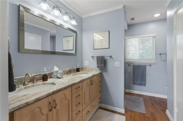 bathroom featuring hardwood / wood-style flooring, vanity, and ornamental molding