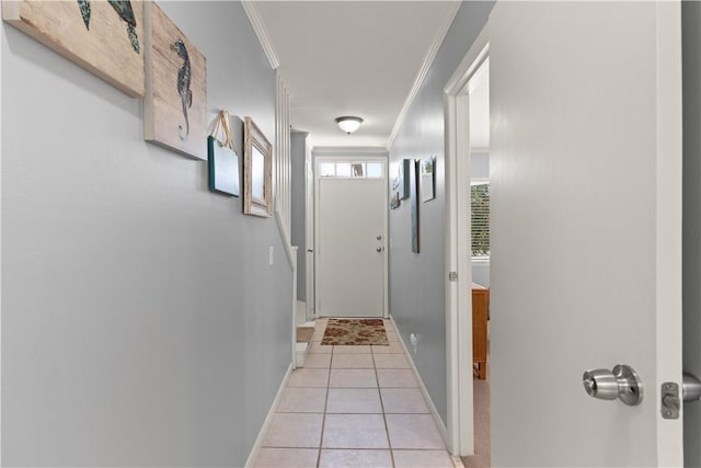 entryway with light tile patterned flooring and ornamental molding