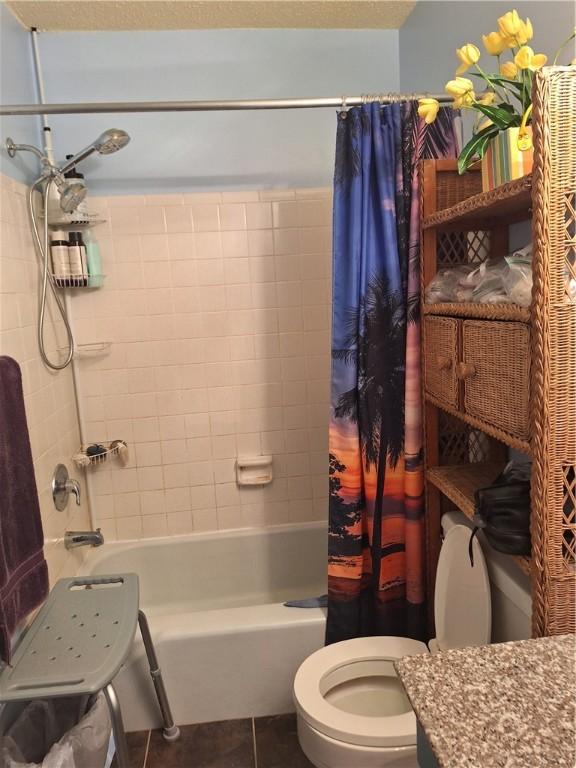 full bathroom featuring tile patterned floors, vanity, toilet, and shower / bath combination with curtain