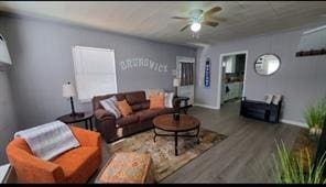 living room featuring wood-type flooring and ceiling fan