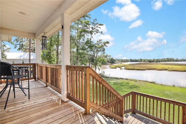 wooden deck featuring a water view and a yard