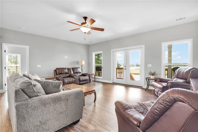 living room featuring ceiling fan, light hardwood / wood-style floors, and french doors