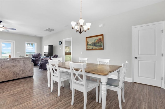 dining room featuring ceiling fan with notable chandelier and dark wood-type flooring