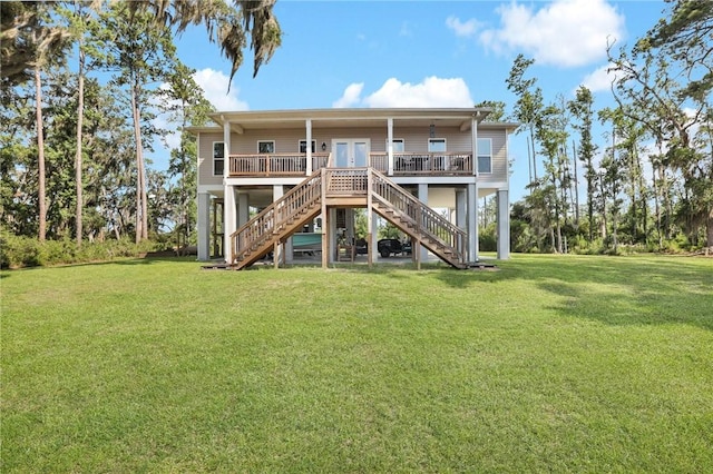 rear view of property featuring covered porch, french doors, and a lawn