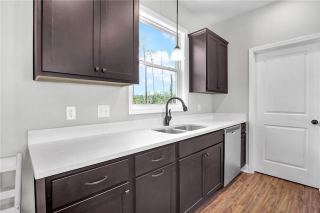 kitchen with stainless steel dishwasher, dark brown cabinetry, sink, hardwood / wood-style flooring, and hanging light fixtures