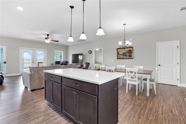 kitchen with french doors, dark brown cabinets, ceiling fan with notable chandelier, decorative light fixtures, and hardwood / wood-style floors