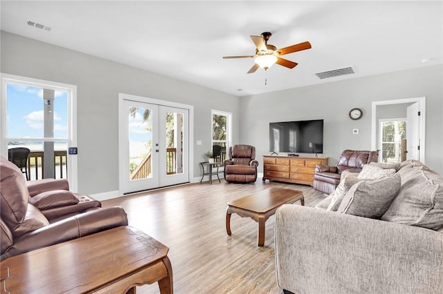 living room with ceiling fan, a healthy amount of sunlight, light hardwood / wood-style flooring, and french doors