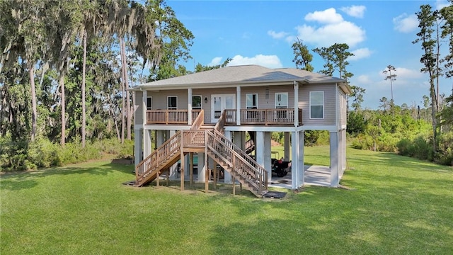 rear view of house featuring a lawn and covered porch