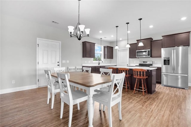 dining area featuring a chandelier and light wood-type flooring