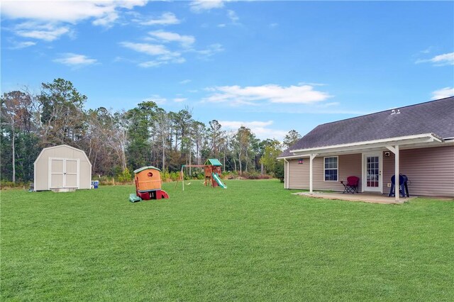 view of yard with a patio area, a playground, and a storage unit