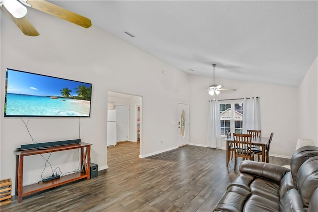 living room featuring ceiling fan, dark wood-type flooring, and vaulted ceiling